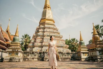 Voyageuse admirant le grand chedi doré du temple Wat Pho à Bangkok lors d'un itinéraire photo en Thaïlande