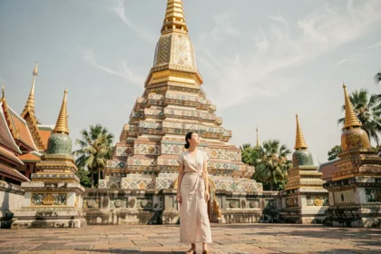 Voyageuse admirant le grand chedi doré du temple Wat Pho à Bangkok lors d'un itinéraire photo en Thaïlande